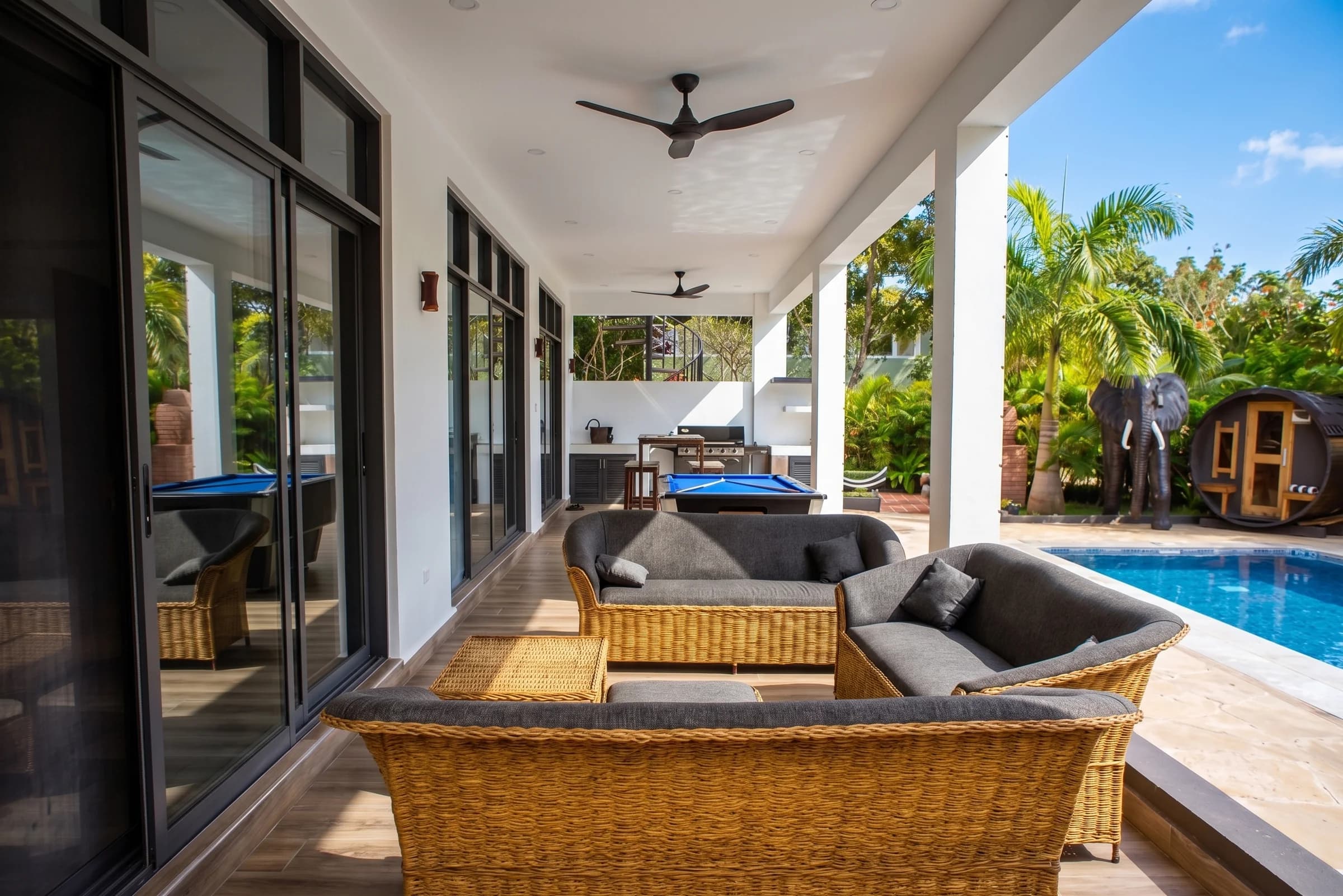 Shaded poolside patio and covered lounge terrace overlooking the swimming pool at The Coastal Estate
