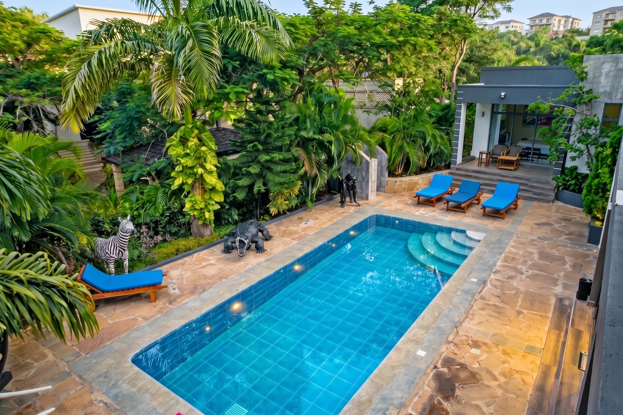 Private swimming pool and sun loungers in secluded walled tropical courtyard at The Coastal Estate